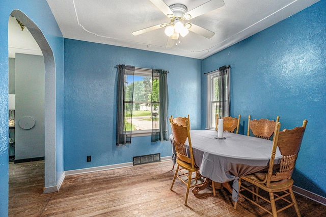 4319 Beckley Rd, Battle Creek, MI 49015 - dining area featuring arched walkways, wood finished floors, a textured wall, baseboards, and ceiling fan