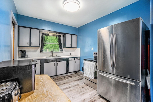 4319 Beckley Rd, Battle Creek, MI 49015 - kitchen featuring appliances with stainless steel finishes, a sink, light wood-style flooring, and light countertops