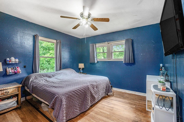 4319 Beckley Rd, Battle Creek, MI 49015 - bedroom featuring multiple windows, wood finished floors, baseboards, and a ceiling fan