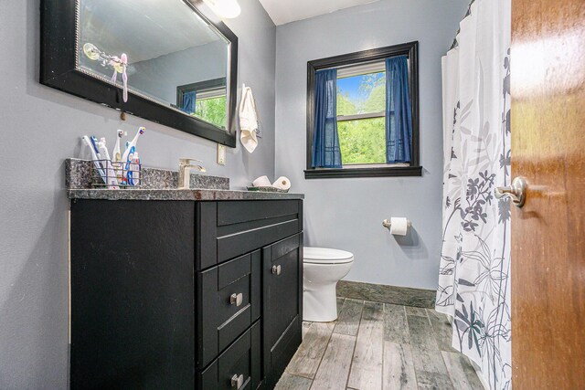4319 Beckley Rd, Battle Creek, MI 49015 - full bathroom with wood finished floors, toilet, vanity, baseboards, and curtained shower