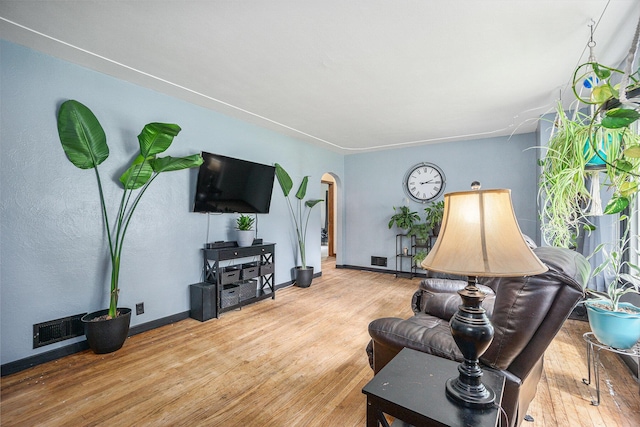 4319 Beckley Rd, Battle Creek, MI 49015 - living area with arched walkways, wood finished floors, and baseboards