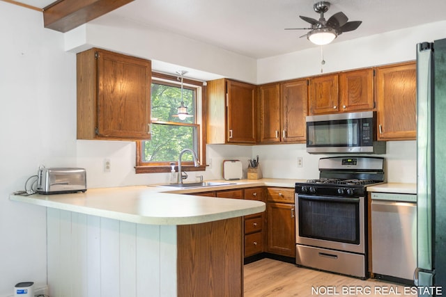 1710 Dykhouse Ave, Grand Haven, MI 49417 - kitchen with stainless steel appliances, a sink, a peninsula, and light countertops