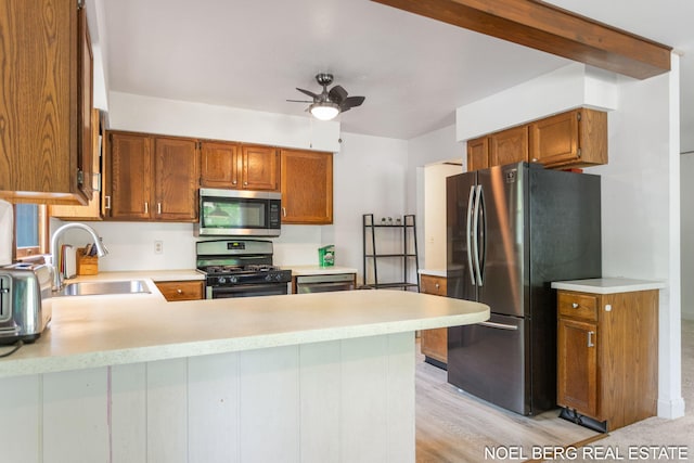 1710 Dykhouse Ave, Grand Haven, MI 49417 - kitchen featuring appliances with stainless steel finishes, a sink, a peninsula, light countertops, and ceiling fan