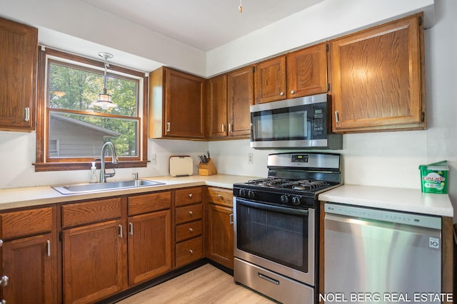 1710 Dykhouse Ave, Grand Haven, MI 49417 - kitchen with stainless steel appliances, a sink, light countertops, and light wood finished floors