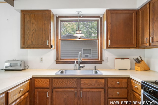 1710 Dykhouse Ave, Grand Haven, MI 49417 - kitchen with a sink, light countertops, pendant lighting, and brown cabinetry