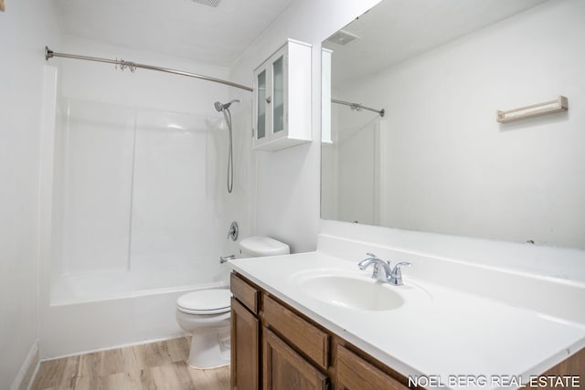 1710 Dykhouse Ave, Grand Haven, MI 49417 - bathroom featuring toilet, vanity, washtub / shower combination, and wood finished floors