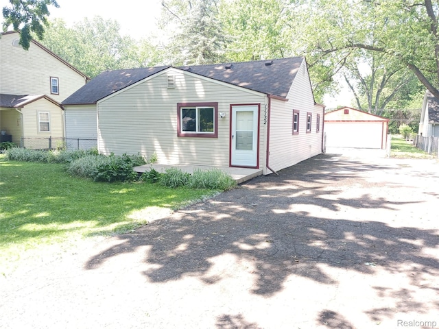 11132 Cape Cod St, Taylor, MI 48180 - view of home's exterior featuring a detached garage, a shingled roof, an outdoor structure, and driveway