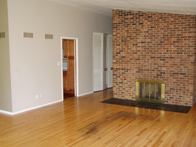 1358 Arroyo Dr, Ypsilanti, MI 48197 - unfurnished living room with wood finished floors, a fireplace, lofted ceiling, and baseboards