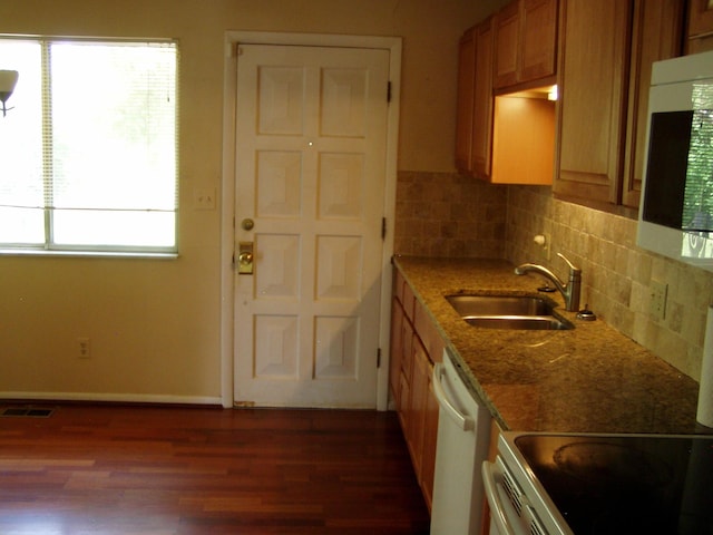 1358 Arroyo Dr, Ypsilanti, MI 48197 - kitchen with a sink, white dishwasher, dark wood-type flooring, brown cabinetry, and dark stone countertops