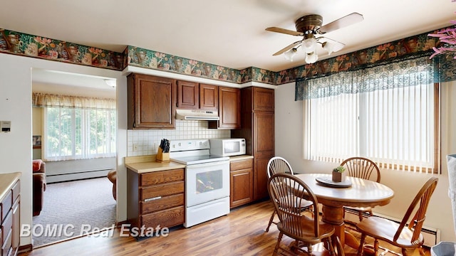5612 Jay Rd, Vassar, MI 48768 - kitchen featuring white appliances, baseboard heating, under cabinet range hood, a ceiling fan, and light countertops