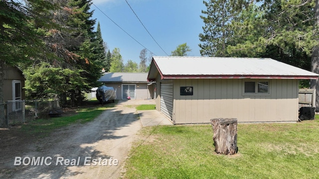 2081 Skiles Dr, Saint Helen, MI 48656 - view of front of property with metal roof, dirt driveway, and an outbuilding