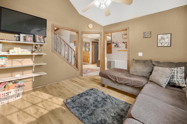 22251 210th Ave, Tustin, MI 49688 - living room with vaulted ceiling, wood finished floors, stairway, ceiling fan, and a textured wall