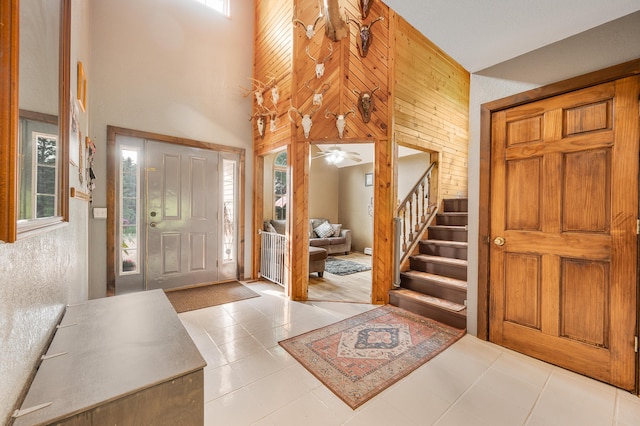 22251 210th Ave, Tustin, MI 49688 - foyer featuring healthy amount of natural light, tile patterned floors, wood walls, stairs, and a towering ceiling
