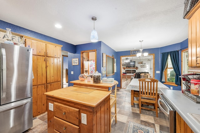 22251 210th Ave, Tustin, MI 49688 - kitchen featuring stainless steel appliances, a chandelier, pendant lighting, a sink, and a center island