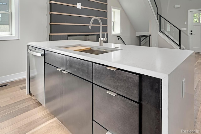3634 Trumbull St Unit 65, Detroit, MI 48208 - kitchen with dishwasher, a sink, baseboards, and light wood-type flooring