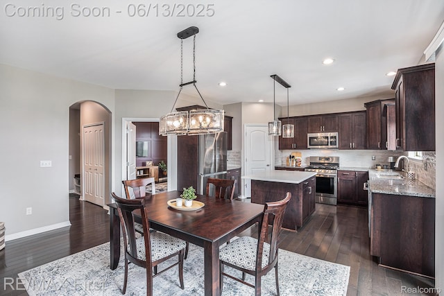 17769 Tiger Dr, Macomb, MI 48042 - dining area with arched walkways, dark wood-type flooring, a chandelier, and recessed lighting