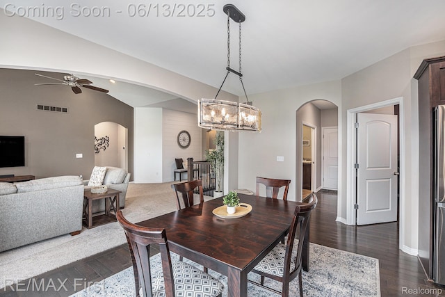 17769 Tiger Dr, Macomb, MI 48042 - dining space with arched walkways, a ceiling fan, dark wood-style floors, a chandelier, and vaulted ceiling