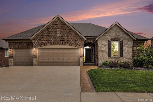 17769 Tiger Dr, Macomb, MI 48042 - french provincial home featuring roof with shingles, concrete driveway, a lawn, a garage, and stone siding