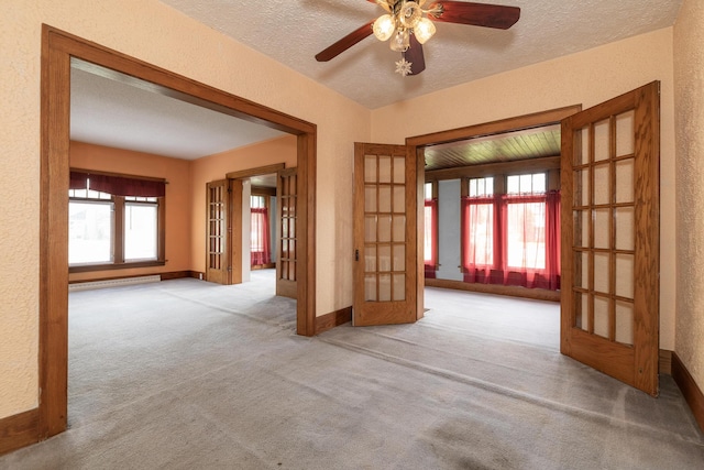 3804 Portage St, Kalamazoo, MI 49001 - unfurnished room with french doors, a baseboard radiator, a textured wall, carpet floors, and a ceiling fan