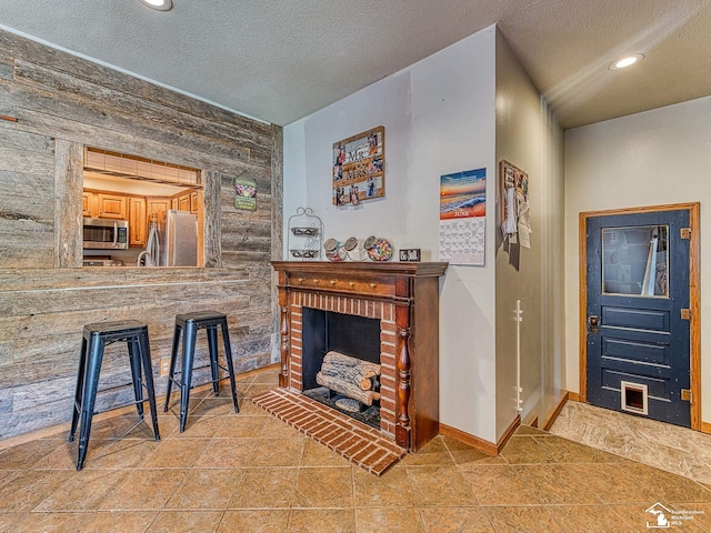 9601 Exeter Rd, Carleton, MI 48117 - living area featuring a textured ceiling, light tile patterned flooring, baseboards, a fireplace, and recessed lighting