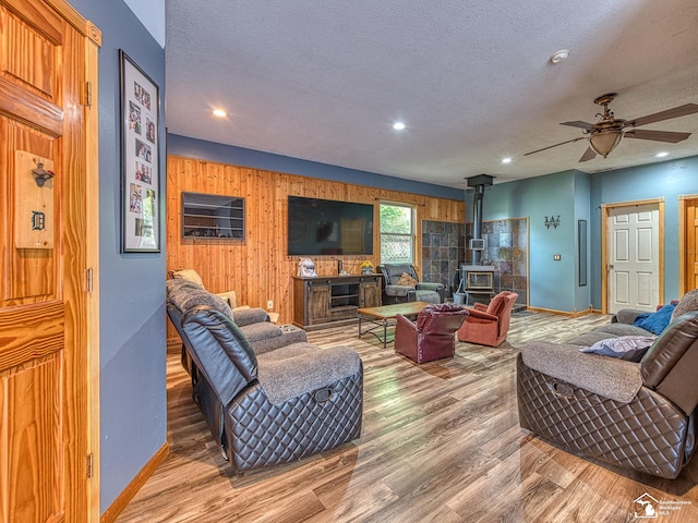 9601 Exeter Rd, Carleton, MI 48117 - living room featuring a wood stove, wood finished floors, baseboards, a textured ceiling, and recessed lighting