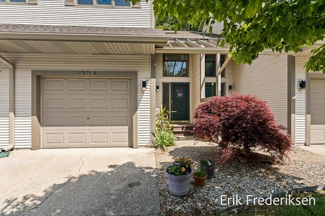 17879 Hidden Dunes Ln Unit D, Spring Lake, MI 49456 - doorway to property with driveway, a shingled roof, and a garage