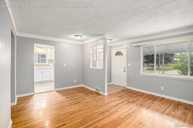 7612 Clippert St, Taylor, MI 48180 - entryway featuring light wood-type flooring, baseboards, and a textured ceiling