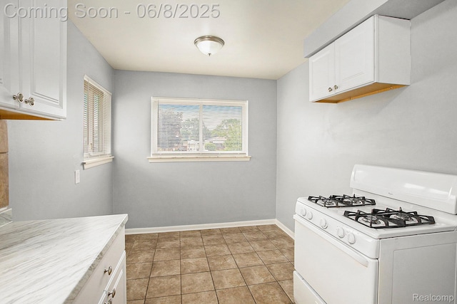 7612 Clippert St, Taylor, MI 48180 - kitchen featuring white gas range oven, white cabinets, baseboards, light countertops, and light tile patterned floors