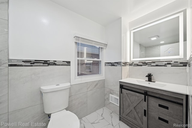 17157 Mendota St, Detroit, MI 48221 - bathroom featuring tile walls, toilet, vanity, and marble finish floors