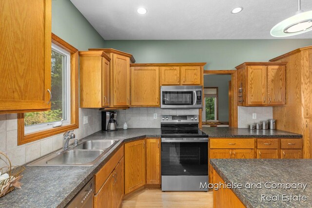 4349 Walter Rd, Wayland, MI 49348 - kitchen with stainless steel appliances, dark countertops, backsplash, brown cabinets, and recessed lighting