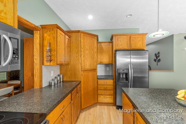 4349 Walter Rd, Wayland, MI 49348 - kitchen with stainless steel appliances, brown cabinetry, light wood-type flooring, backsplash, and hanging light fixtures