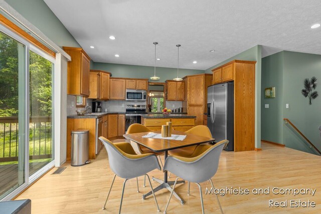 4349 Walter Rd, Wayland, MI 49348 - kitchen with stainless steel appliances, light wood-style floors, dark countertops, brown cabinetry, and recessed lighting