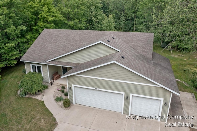 4349 Walter Rd, Wayland, MI 49348 - view of front of property featuring an attached garage, concrete driveway, roof with shingles, and a view of trees