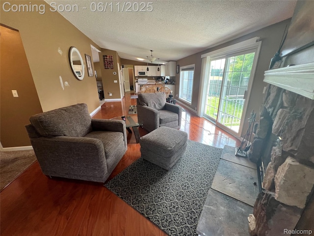 5550 Howe Rd, Grand Blanc, MI 48439 - living area with a textured ceiling, a fireplace, baseboards, and wood finished floors