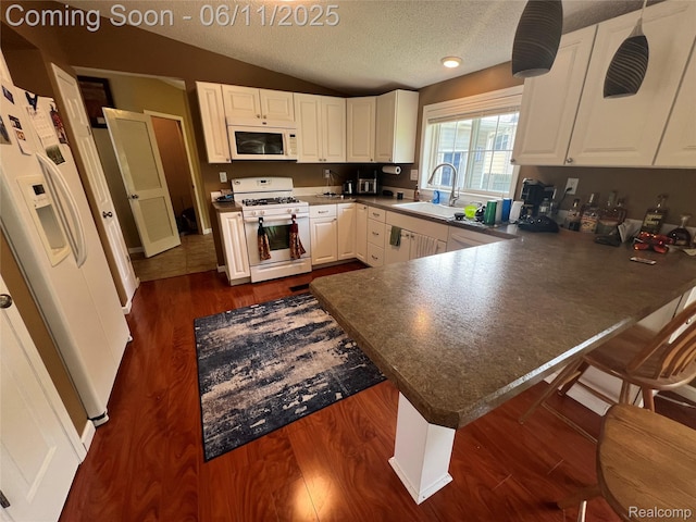 5550 Howe Rd, Grand Blanc, MI 48439 - kitchen featuring white appliances, a sink, a peninsula, vaulted ceiling, and dark countertops