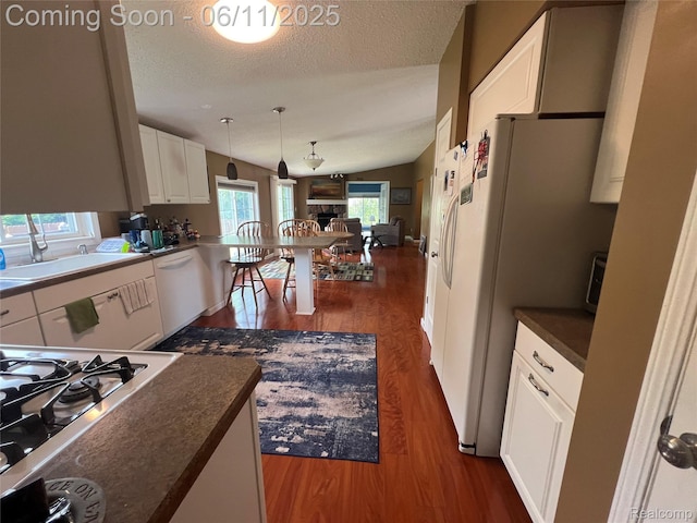 5550 Howe Rd, Grand Blanc, MI 48439 - kitchen with white appliances, dark countertops, dark wood-type flooring, white cabinets, and a textured ceiling