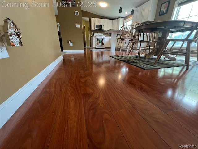 5550 Howe Rd, Grand Blanc, MI 48439 - kitchen featuring white appliances, baseboards, healthy amount of natural light, white cabinets, and lofted ceiling