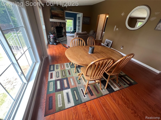 5550 Howe Rd, Grand Blanc, MI 48439 - dining room with a fireplace, wood finished floors, and baseboards