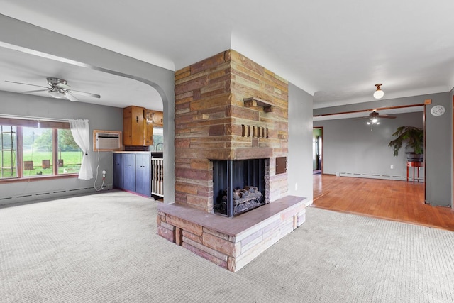5244 Sand Creek Highway, Adrian, MI 49221 - unfurnished living room with a ceiling fan, baseboard heating, light colored carpet, and a stone fireplace