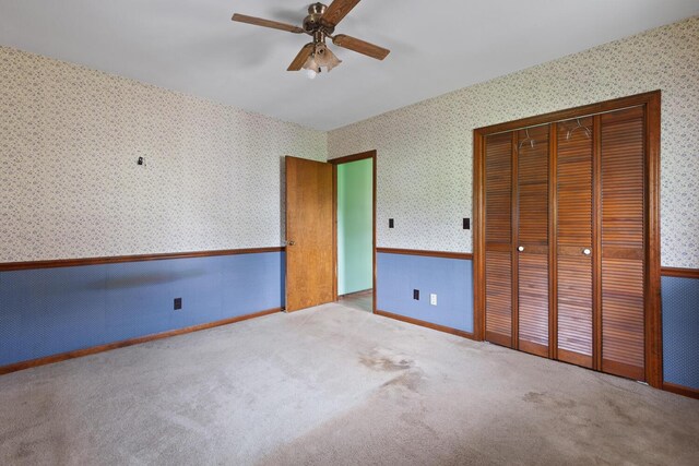 5244 Sand Creek Highway, Adrian, MI 49221 - unfurnished bedroom featuring wallpapered walls, a closet, wainscoting, a ceiling fan, and carpet