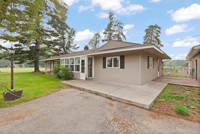 5244 Sand Creek Highway, Adrian, MI 49221 - view of front facade featuring a front lawn, a chimney, and a patio area