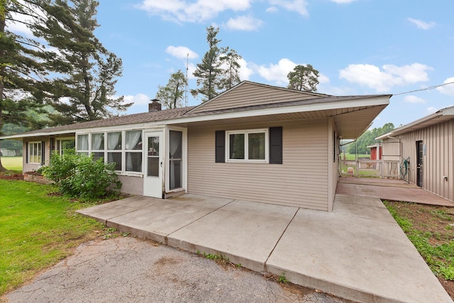 5244 Sand Creek Highway, Adrian, MI 49221 - rear view of property featuring a chimney, a patio area, a lawn, and a deck