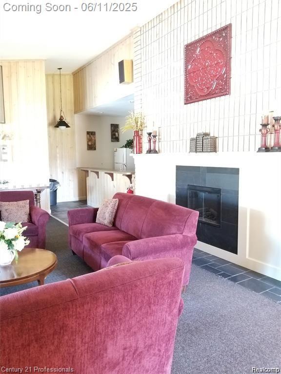 40859 Newport Dr, Plymouth, MI 48170 - living room featuring a glass covered fireplace and dark carpet