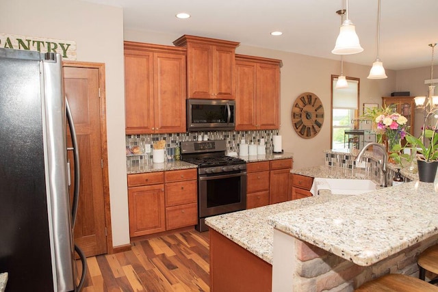 13952 Stowell Rd, Dundee, MI 48131 - kitchen featuring stainless steel appliances, a sink, a kitchen breakfast bar, tasteful backsplash, and light wood-style flooring