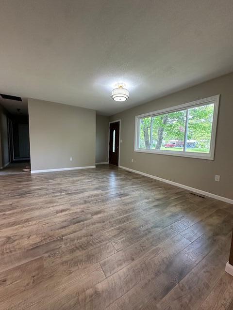 5511 Sunset Ct, Oscoda, MI 48750 - spare room featuring baseboards and wood finished floors