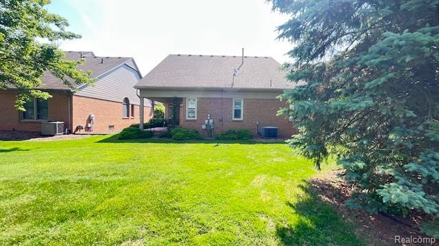 43573 E Perignon Dr N, Sterling Heights, MI 48314 - rear view of property with central AC, a yard, and brick siding