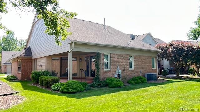 43573 E Perignon Dr N, Sterling Heights, MI 48314 - rear view of house featuring a yard, brick siding, and central air condition unit