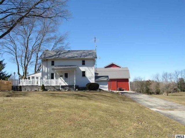 7090 Hallenbeck Hwy, Manitou Beach, MI 49253 - back of house with a lawn, an outdoor structure, and driveway