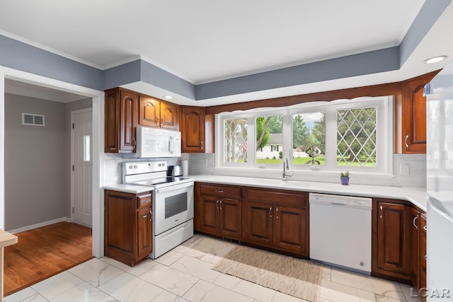 603 Outer Dr, Tecumseh, MI 49286 - kitchen featuring white appliances, a sink, light countertops, light marble finish flooring, and ornamental molding