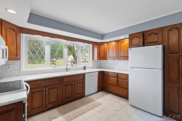 603 Outer Dr, Tecumseh, MI 49286 - kitchen with white appliances, a sink, light marble finish flooring, light countertops, and tasteful backsplash